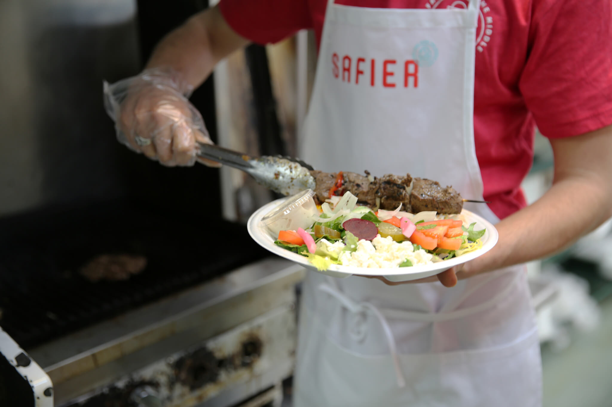 employee serving food in Safier apron