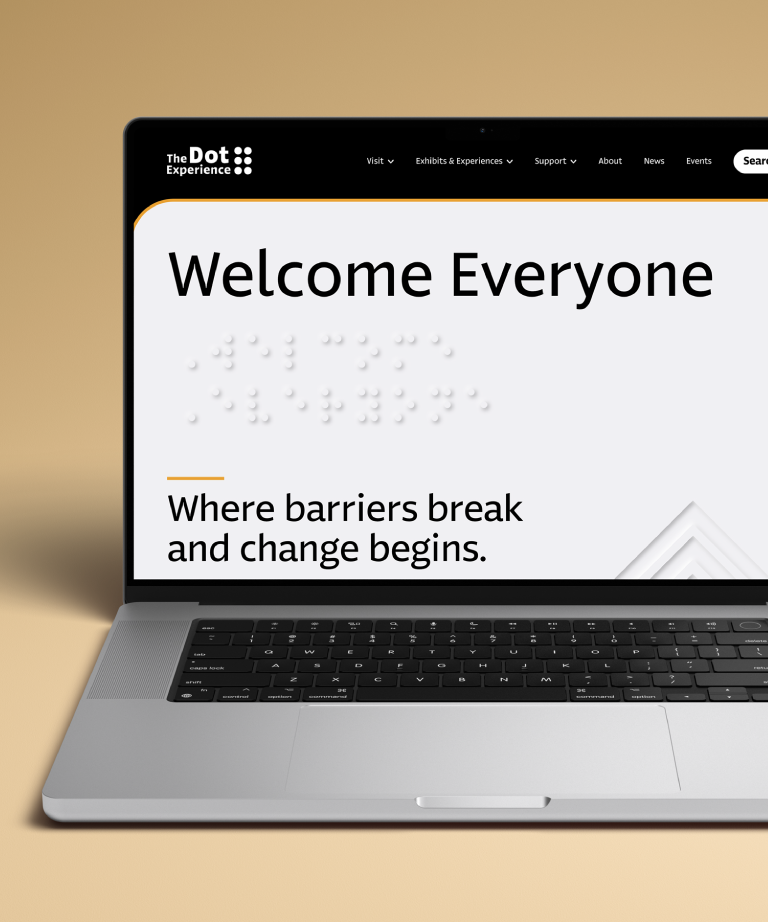 A laptop displays a website with the text “Welcome Everyone” and braille dots above the phrase “Where barriers break and change begins.” The site header reads The Dot Experience.